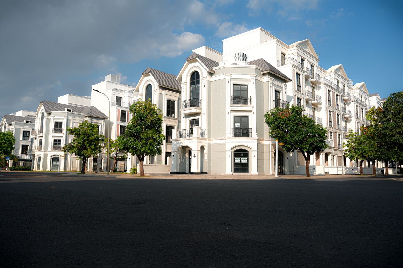 About A modern apartment complex with classic architectural design under a bright blue sky.
