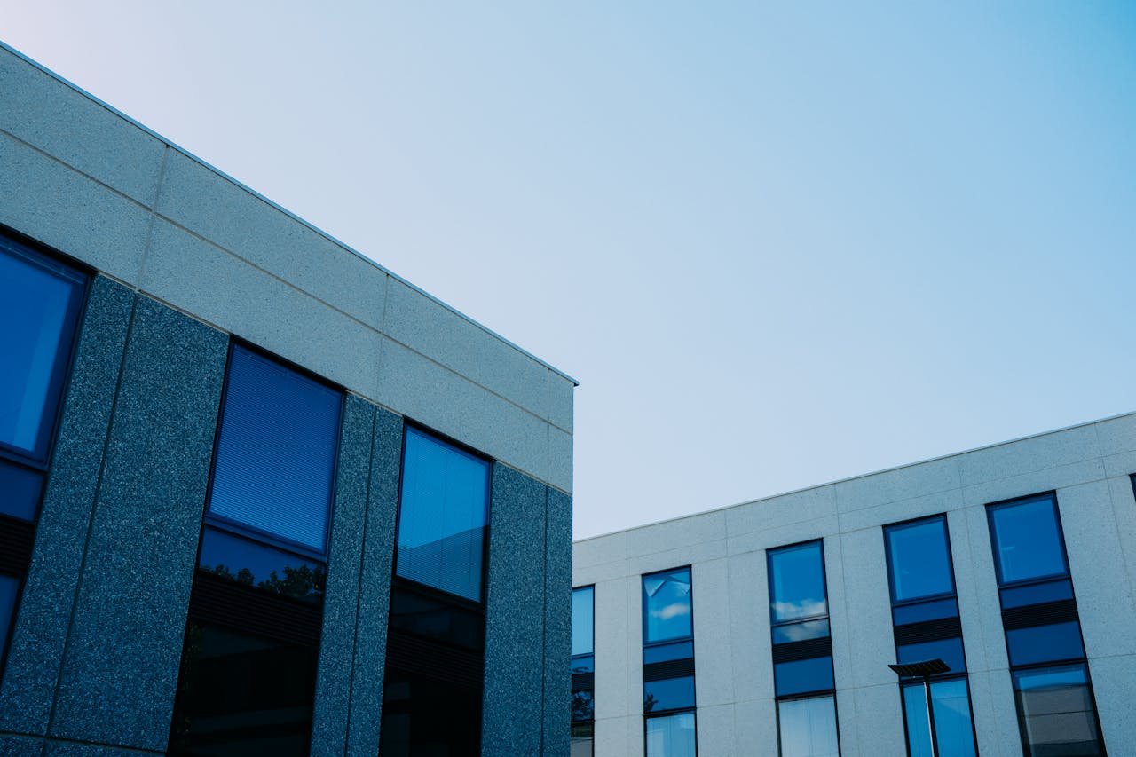 Offerings From below of contemporary office buildings with reflection in windows located in city
